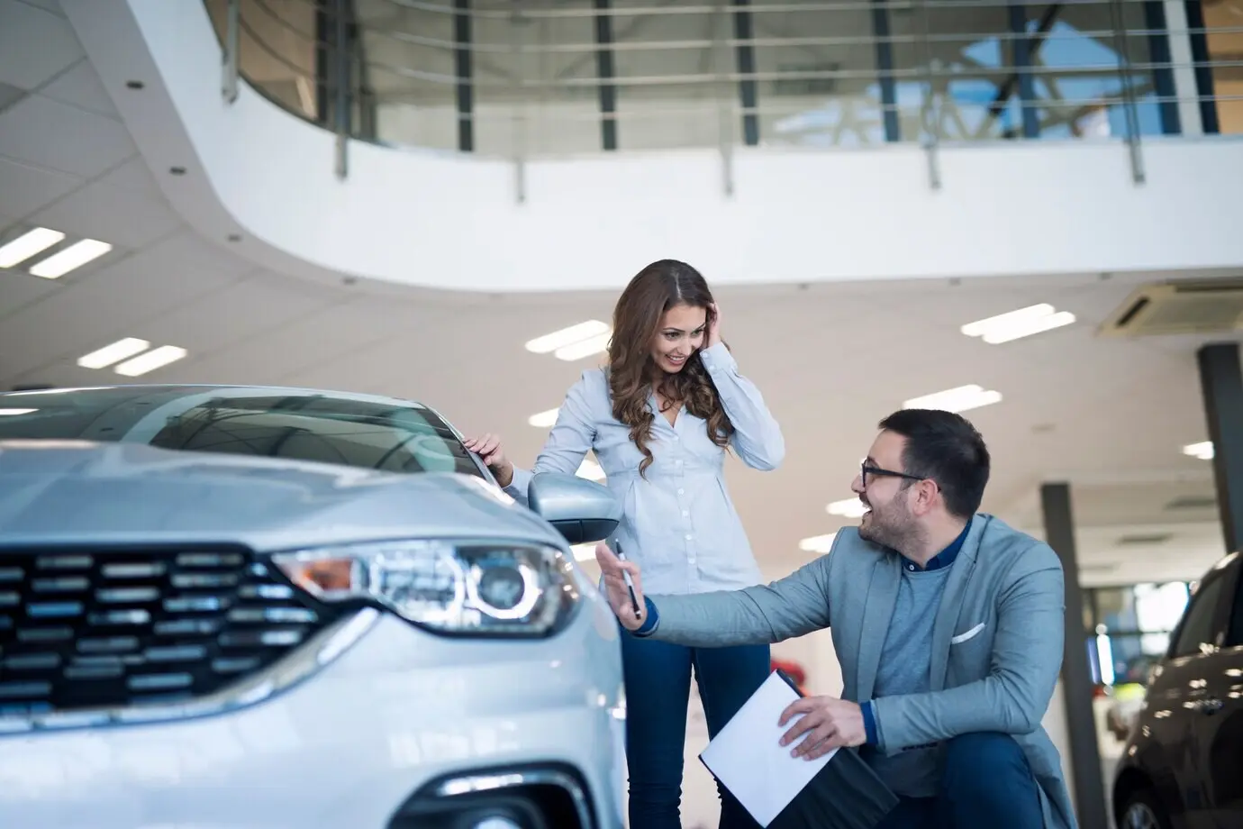 A car salesperson presenting a new car to a customer.
